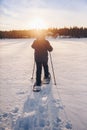 Man in snowshoes is walking with beautiful sunrise light. Outdoor winter activity Royalty Free Stock Photo