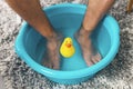 Man soaking his feet in a basin