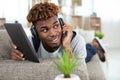 man on sofa with digital tablet and headphone