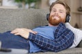 man on sofa with headphones enjoying music