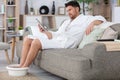 man on sofa soaking feet Royalty Free Stock Photo