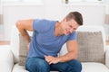 Man On Sofa Suffering From Backpain Royalty Free Stock Photo
