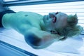 Man in solarium enjoying sunbathing on tanning bed