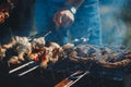 A man with a solid clock fry sausages on the grill and barbecue Royalty Free Stock Photo