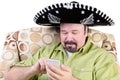 Man in sombrero texting on mobile