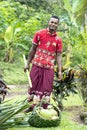 Fiji, native Man with Machete collecting coconut in handmade basket