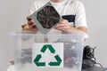 Man sorting broken computer parts in recycle container