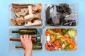 Man Sorts Garbage. Four transparent containers with trash: glass, plastic, organic trash, paper on a blue background