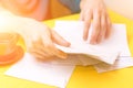 A man sorts the mail. Male hands the envelopes on a yellow background, a red coffee Cup.