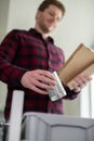 Man Sorting Recycling Into Kitchen Bin At Home