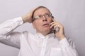 Man speaking by phone and holding his hand on head in fear or surprise, shock Royalty Free Stock Photo