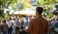Man speaking to crowd in outdoor setting with blurred background and greenery Royalty Free Stock Photo