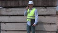 Man speaking on walky talky near construction blocks