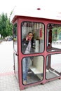 Man speaks by phone in a call box