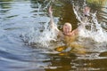 Cheerful resting in the pond, a man splashes water