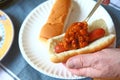 Adding chili to hot dog