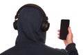 A man in a sports jacket with a hood on his head listens to music with headphones on his smartphone. Royalty Free Stock Photo