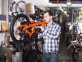 Man in sports workshop mounts bike using special tools