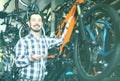 Man in sports workshop mounts bike using special tools
