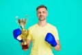 Man sportsman boxer hold champion cup as winner in boxing sport isolated on blue Royalty Free Stock Photo