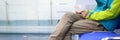 Man in sportswear is waiting on chair in hallway