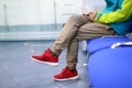 Man in sportswear is waiting on chair in hallway