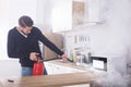 Man Spraying Fire Extinguisher On Microwave Oven Royalty Free Stock Photo