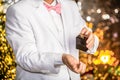 Man spraying luxury perfume. Male fragrance, perfumery, cosmetics. Smell perfume, suit. Perfume or cologne bottle Royalty Free Stock Photo