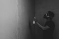 Man spraying paint on the wall. spray can in the hand. face in respirator Royalty Free Stock Photo