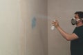 Man spraying paint on the wall. spray can in the hand. face in respirator Royalty Free Stock Photo