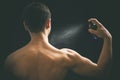 Man spraying perfume on black background Royalty Free Stock Photo