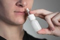 A man sprays a spray into his nose for a runny nose. Close up Royalty Free Stock Photo