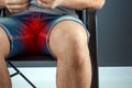 The man spread his legs, close-up Pain in the groin. Men`s problems, acute pain, inconvenience