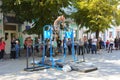 A man in the square does gymnastic exercises on uneven bars