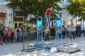 A man in the square does gymnastic exercises on uneven bars