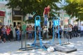 A man in the square does gymnastic exercises on uneven bars