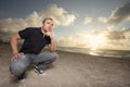 Man squatting on the beach Royalty Free Stock Photo