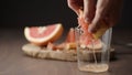 man squeeze grapefruit into tumbler glass on wood table Royalty Free Stock Photo