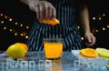 man squeeze orange above glass near slice fresh lemon and orange, ice Royalty Free Stock Photo