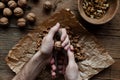Man squeezes walnuts over wooden table Royalty Free Stock Photo