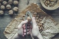 Man squeezes walnuts over wooden table Royalty Free Stock Photo