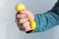 Man squeezing antistress ball on grey background, closeup