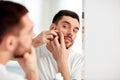 Man squeezing pimple at bathroom mirror Royalty Free Stock Photo