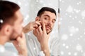 Man squeezing pimple at bathroom mirror Royalty Free Stock Photo