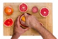 Man squeezing ruby grapefruit halves Royalty Free Stock Photo