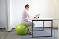 Man on stability ball working with tablet Royalty Free Stock Photo