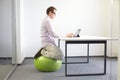 Man on stability ball working with tablet Royalty Free Stock Photo