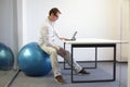 Man on stability ball working with tablet Royalty Free Stock Photo