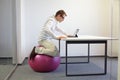 Man on stability ball working with tablet Royalty Free Stock Photo