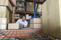 Man Stacking Boxes In Warehouse